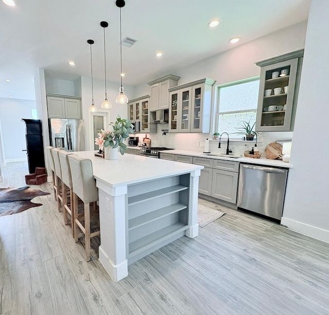 55 Ruskin Dr W, Montgomery, TX 77356 - kitchen with stainless steel appliances, a sink, decorative backsplash, light wood-style flooring, and recessed lighting