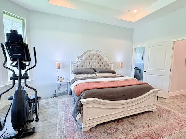 55 Ruskin Dr W, Montgomery, TX 77356 - bedroom with light wood-type flooring, a raised ceiling, and baseboards