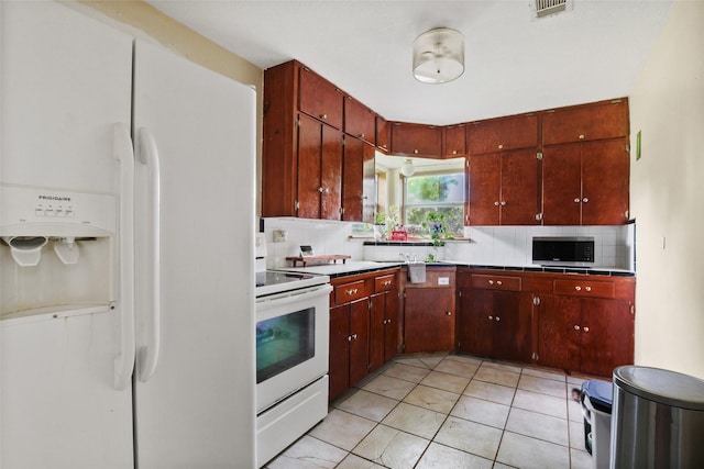 700 Ross St, La Marque, TX 77568 - kitchen featuring white appliances, backsplash, light countertops, and light tile patterned floors