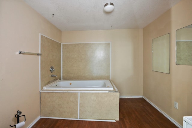 700 Ross St, La Marque, TX 77568 - bathroom featuring wood finished floors, baseboards, and a relaxing tiled tub