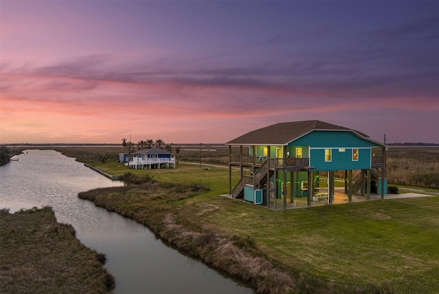 1109 Pompano Dr, Crystal Beach, TX 77650 - playground at dusk with stairway, a deck with water view, and a lawn