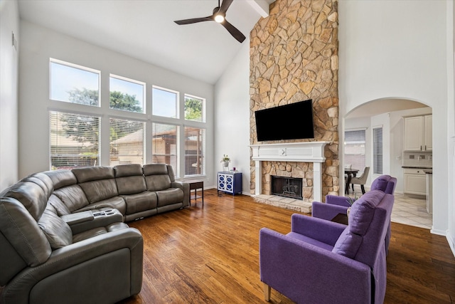 12814 Prestige Row, Houston, TX 77065 - living area with high vaulted ceiling, a ceiling fan, a stone fireplace, arched walkways, and beam ceiling
