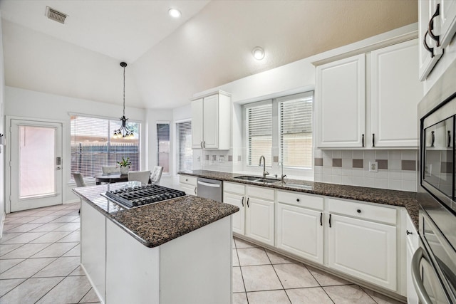 12814 Prestige Row, Houston, TX 77065 - kitchen with lofted ceiling, stainless steel appliances, a sink, light tile patterned floors, and a kitchen island