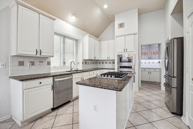 12814 Prestige Row, Houston, TX 77065 - kitchen featuring appliances with stainless steel finishes, a sink, a kitchen island, decorative backsplash, and vaulted ceiling