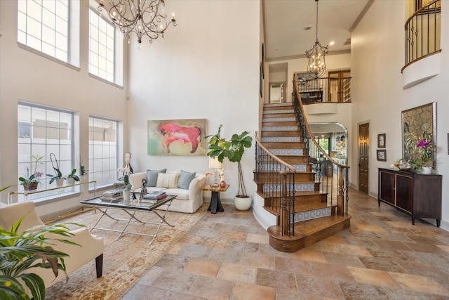 foyer featuring a chandelier, a high ceiling, stairway, and stone finish flooring