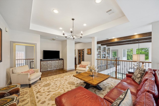living room featuring a chandelier, wood finished floors, recessed lighting, a tray ceiling, and baseboards