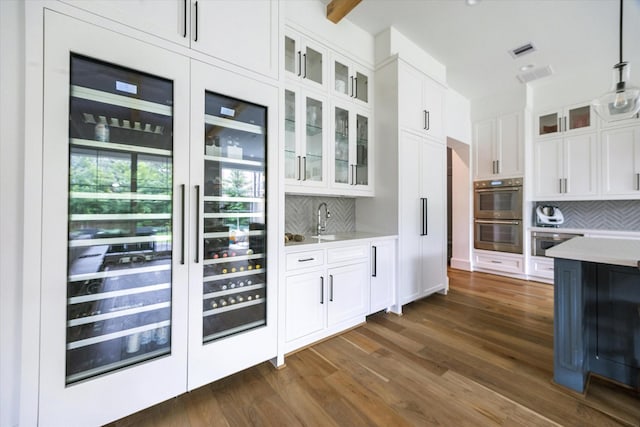 2224 N Blvd, Houston, TX 77098 - bar featuring stainless steel double oven, backsplash, dark wood finished floors, and a sink