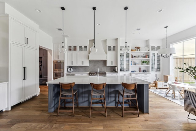 2224 N Blvd, Houston, TX 77098 - kitchen featuring premium range hood, stainless steel double oven, white cabinetry, open shelves, and decorative backsplash