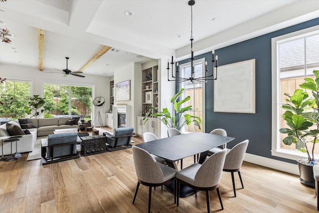 2224 N Blvd, Houston, TX 77098 - dining space with light wood-type flooring, a ceiling fan, a glass covered fireplace, beam ceiling, and baseboards
