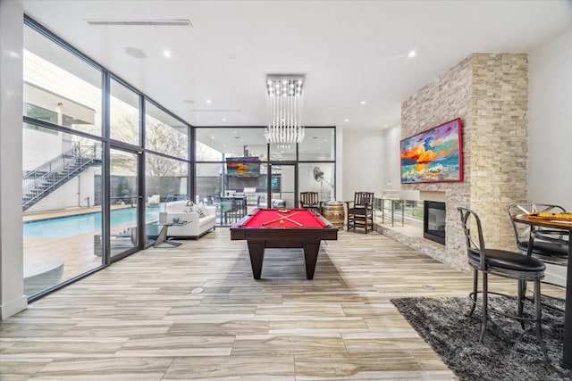 4002 Chatham Ln, Houston, TX 77027 - game room with expansive windows, billiards, a fireplace, and a chandelier