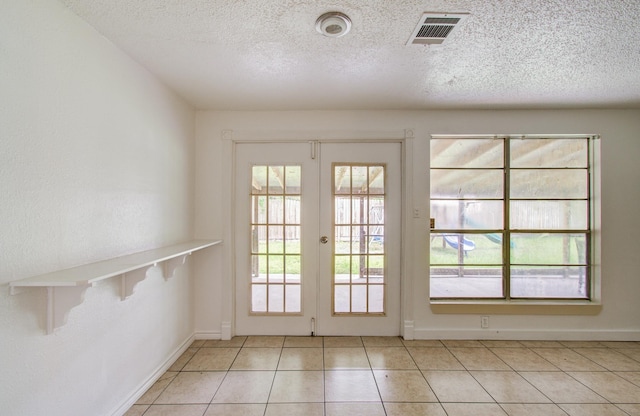 2614 Lemonwood Ln, Houston, TX 77038 - doorway to outside with a textured ceiling, light tile patterned floors, and baseboards