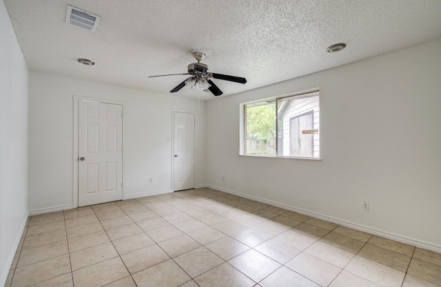 2614 Lemonwood Ln, Houston, TX 77038 - empty room with ceiling fan, a textured ceiling, baseboards, and light tile patterned floors