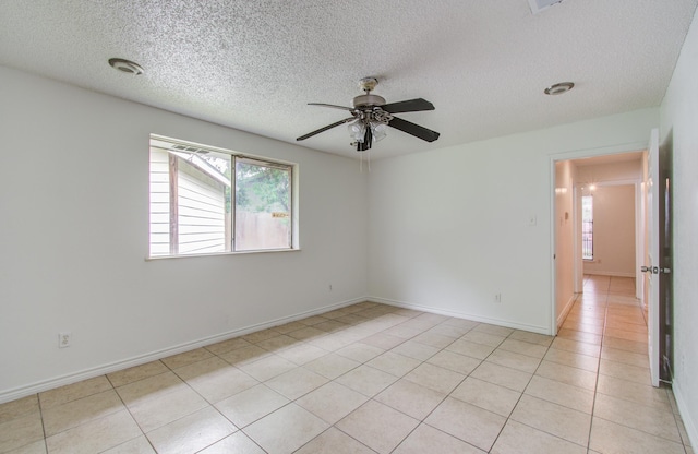 2614 Lemonwood Ln, Houston, TX 77038 - empty room with a ceiling fan, a textured ceiling, light tile patterned flooring, and baseboards