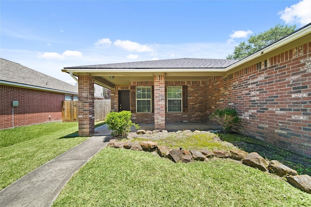 1928 Cypress Ln, Dayton, TX 77535 - view of exterior entry with brick siding and roof with shingles
