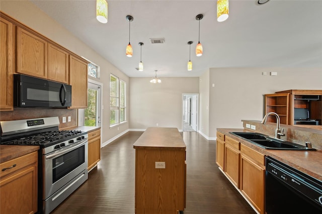 1928 Cypress Ln, Dayton, TX 77535 - kitchen featuring black appliances, a sink, dark wood-style floors, and a kitchen island