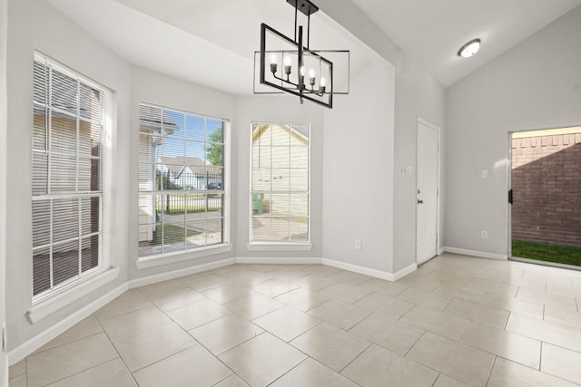 unfurnished dining area with light tile patterned floors, baseboards, a chandelier, and lofted ceiling
