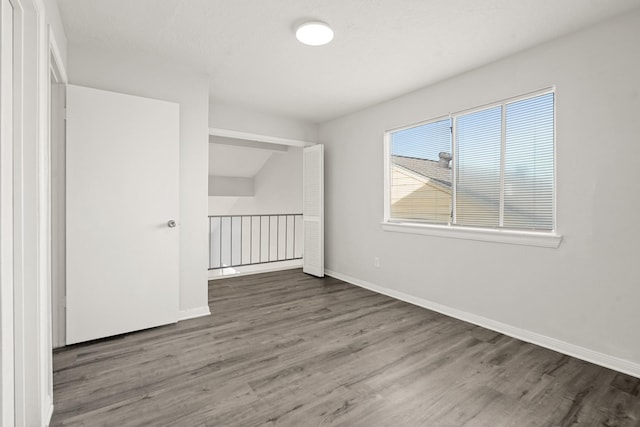 unfurnished bedroom featuring wood finished floors and baseboards