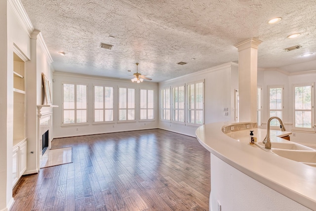 1114 Ridgeburg Ct, Houston, TX 77077 - unfurnished living room with crown molding, wood finished floors, a textured ceiling, a ceiling fan, and a tile fireplace