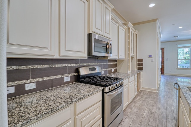 1184 Nelson Falls Ln, Houston, TX 77008 - kitchen featuring stainless steel appliances, decorative backsplash, light stone counters, baseboards, and recessed lighting