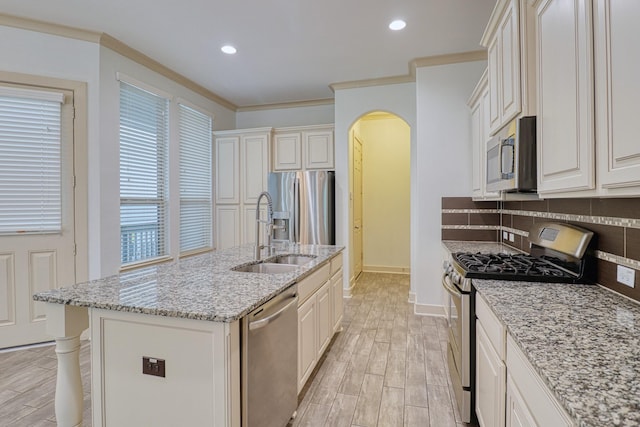 1184 Nelson Falls Ln, Houston, TX 77008 - kitchen featuring stainless steel appliances, a sink, arched walkways, decorative backsplash, and baseboards
