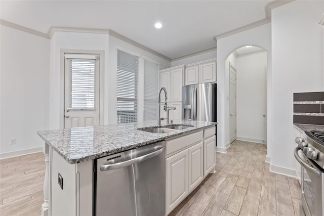 1184 Nelson Falls Ln, Houston, TX 77008 - kitchen with stainless steel appliances, a sink, arched walkways, an island with sink, and light wood finished floors