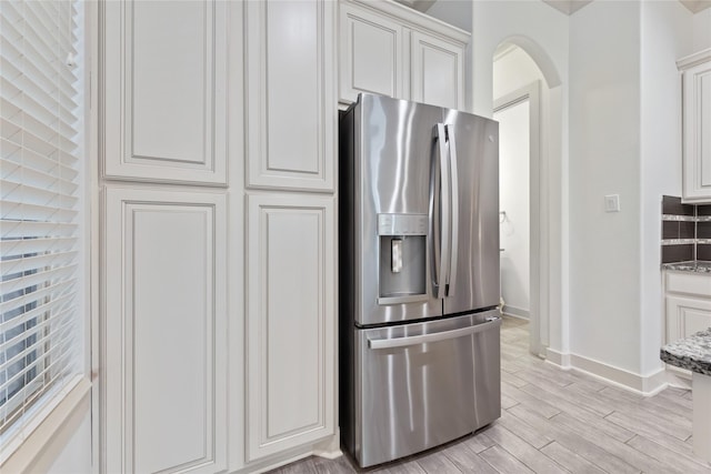 1184 Nelson Falls Ln, Houston, TX 77008 - kitchen featuring stainless steel fridge, baseboards, white cabinets, light wood-style floors, and light stone counters