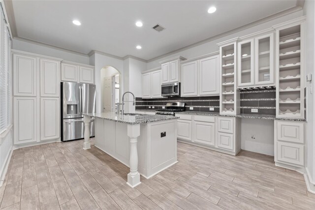 1184 Nelson Falls Ln, Houston, TX 77008 - kitchen featuring appliances with stainless steel finishes, a sink, arched walkways, decorative backsplash, and white cabinetry