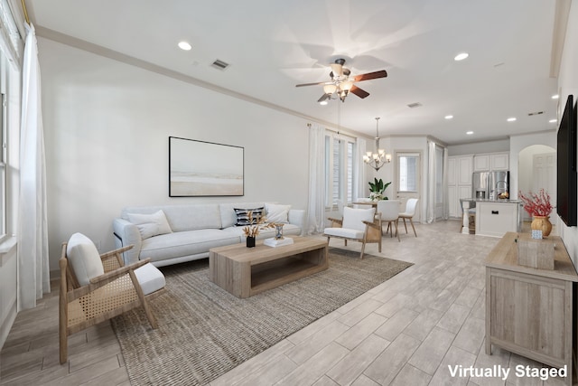 1184 Nelson Falls Ln, Houston, TX 77008 - living room with ceiling fan, a chandelier, arched walkways, light wood-type flooring, and crown molding