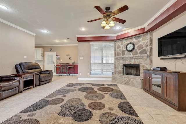 9822 El Chaco St, Baytown, TX 77521 - living room with light tile patterned floors, ornamental molding, a ceiling fan, a stone fireplace, and baseboards