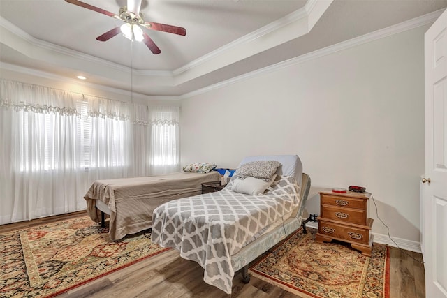 9822 El Chaco St, Baytown, TX 77521 - bedroom featuring a raised ceiling, ornamental molding, wood finished floors, ceiling fan, and baseboards
