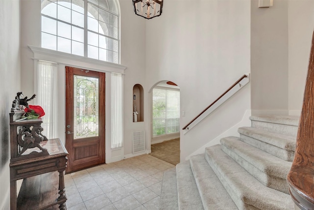 9822 El Chaco St, Baytown, TX 77521 - foyer entrance with light tile patterned flooring, plenty of natural light, stairway, a towering ceiling, and baseboards