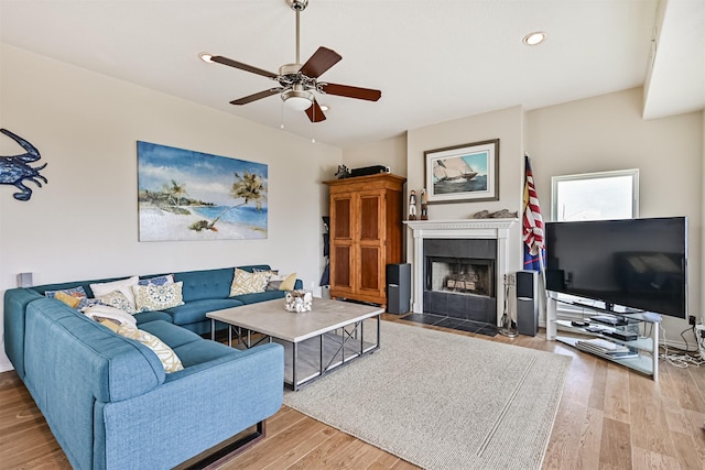 living room with wood finished floors, ceiling fan, a fireplace with flush hearth, and recessed lighting