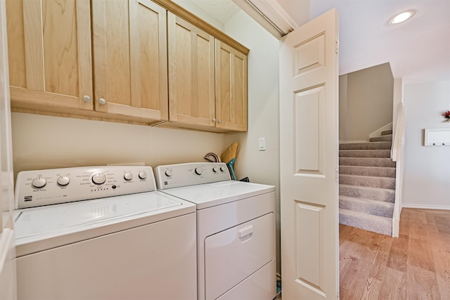 laundry area featuring cabinet space, light wood finished floors, washer and dryer, recessed lighting, and baseboards