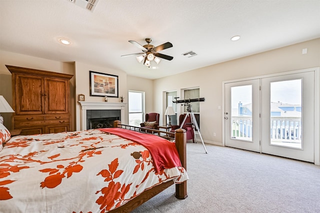 bedroom featuring access to exterior, light carpet, recessed lighting, a tile fireplace, and a ceiling fan
