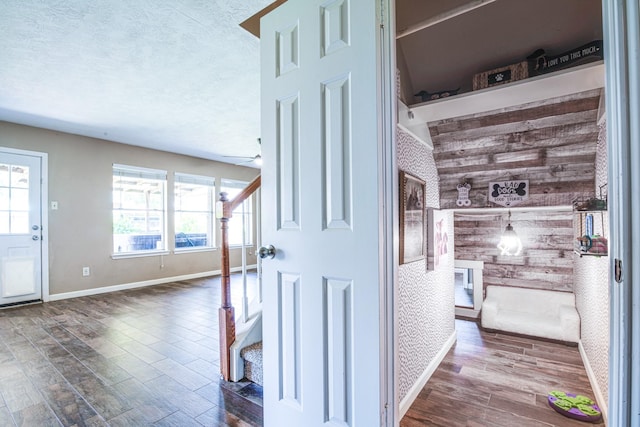 10835 Spruce Dr S, La Porte, TX 77571 - hall with healthy amount of natural light, dark wood finished floors, stairway, baseboards, and a textured ceiling