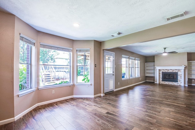 10835 Spruce Dr S, La Porte, TX 77571 - unfurnished living room with a textured ceiling, baseboards, plenty of natural light, and wood finished floors