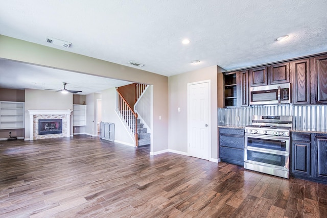 10835 Spruce Dr S, La Porte, TX 77571 - kitchen featuring stainless steel appliances, dark wood-type flooring, a ceiling fan, baseboards, and dark brown cabinetry