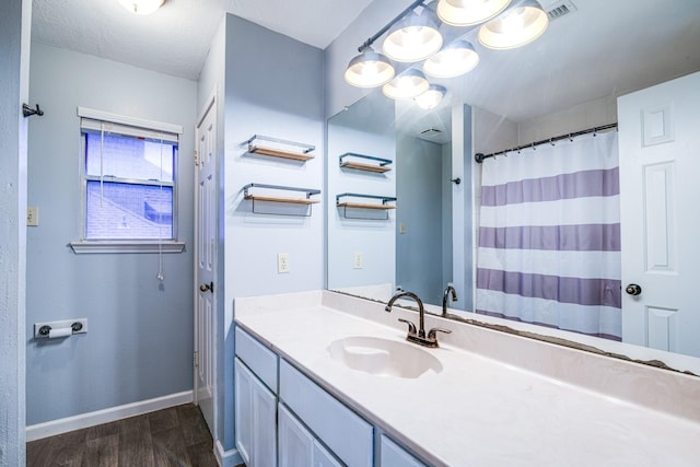 10835 Spruce Dr S, La Porte, TX 77571 - full bathroom featuring wood finished floors, baseboards, vanity, and curtained shower