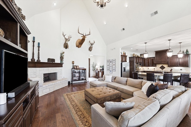 living area featuring high vaulted ceiling, dark wood-style flooring, a fireplace, and recessed lighting
