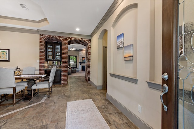 9010 Kapri Ln, Houston, TX 77025 - entrance foyer featuring ornamental molding, arched walkways, baseboards, a ceiling fan, and stone finish floors