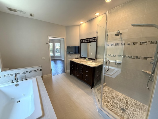2810 Bright Trl, Sugar Land, TX 77479 - full bath featuring a tub with jets, a stall shower, recessed lighting, vanity, and wood finished floors