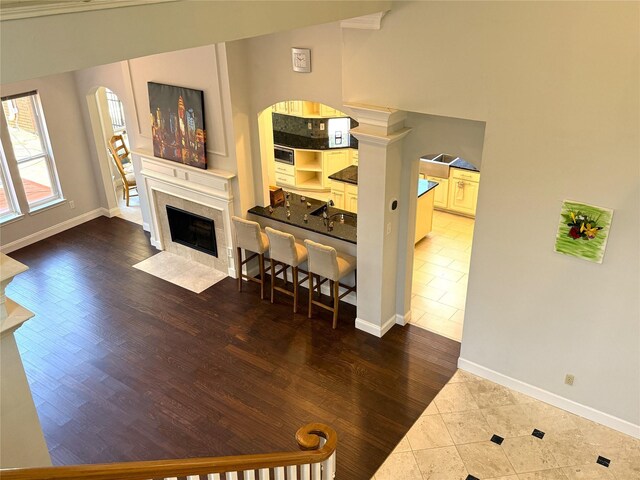 2810 Bright Trl, Sugar Land, TX 77479 - living room featuring tile patterned flooring, arched walkways, a tile fireplace, and baseboards