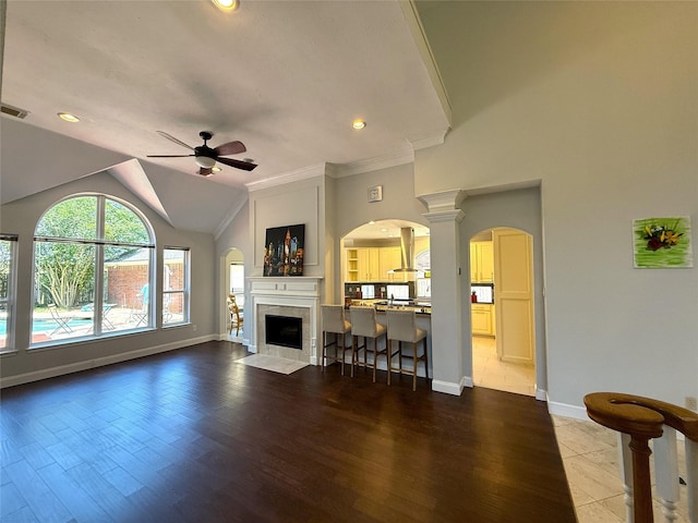 2810 Bright Trl, Sugar Land, TX 77479 - living room featuring arched walkways, a ceiling fan, baseboards, dark wood-style floors, and crown molding
