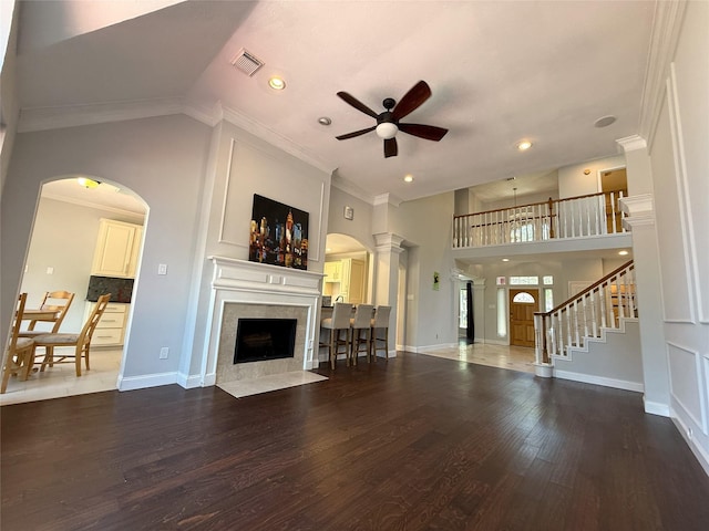 2810 Bright Trl, Sugar Land, TX 77479 - living area with a ceiling fan, a tiled fireplace, wood finished floors, arched walkways, and ornamental molding
