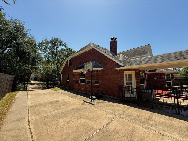 2810 Bright Trl, Sugar Land, TX 77479 - back of house featuring fence, a chimney, brick siding, and roof with shingles
