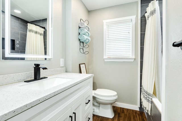 2735 County Road 208, Danbury, TX 77534 - bathroom with toilet, wood finished floors, vanity, baseboards, and shower / tub combo