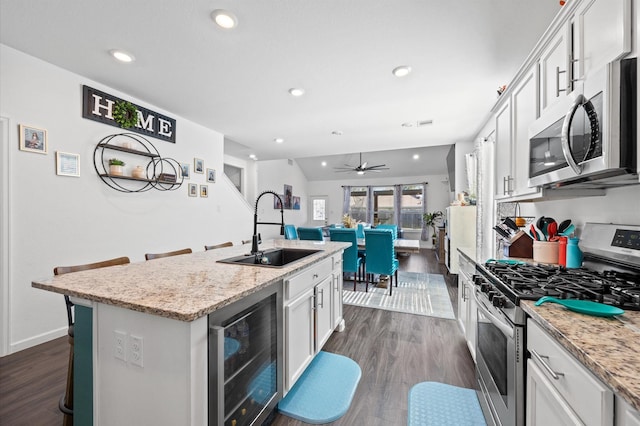 13215 Rowan Green Dr, Humble, TX 77346 - kitchen featuring appliances with stainless steel finishes, beverage cooler, a sink, a center island with sink, and dark wood-style floors