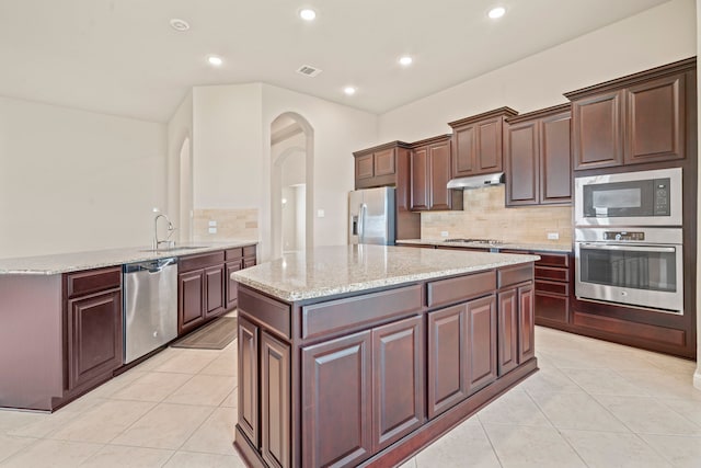28010 Drifters Bend Dr, Spring, TX 77386 - kitchen featuring appliances with stainless steel finishes, a sink, under cabinet range hood, light tile patterned floors, and recessed lighting