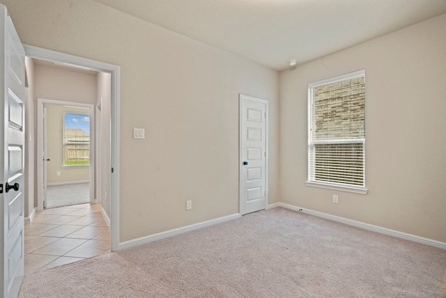 28010 Drifters Bend Dr, Spring, TX 77386 - empty room featuring light carpet, baseboards, and light tile patterned floors