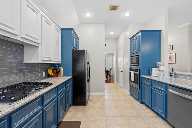 14123 Sherburn Manor Dr, Cypress, TX 77429 - kitchen featuring appliances with stainless steel finishes, blue cabinetry, backsplash, light tile patterned floors, and recessed lighting